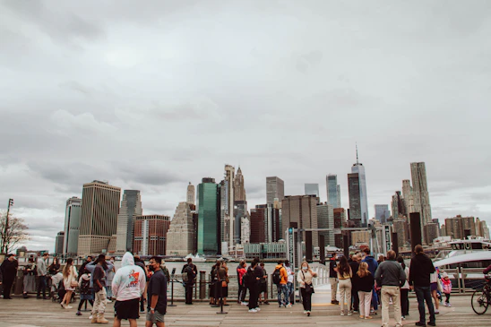 A diverse group of friends enjoying a lively outdoor meetup with city skyline in the background.
