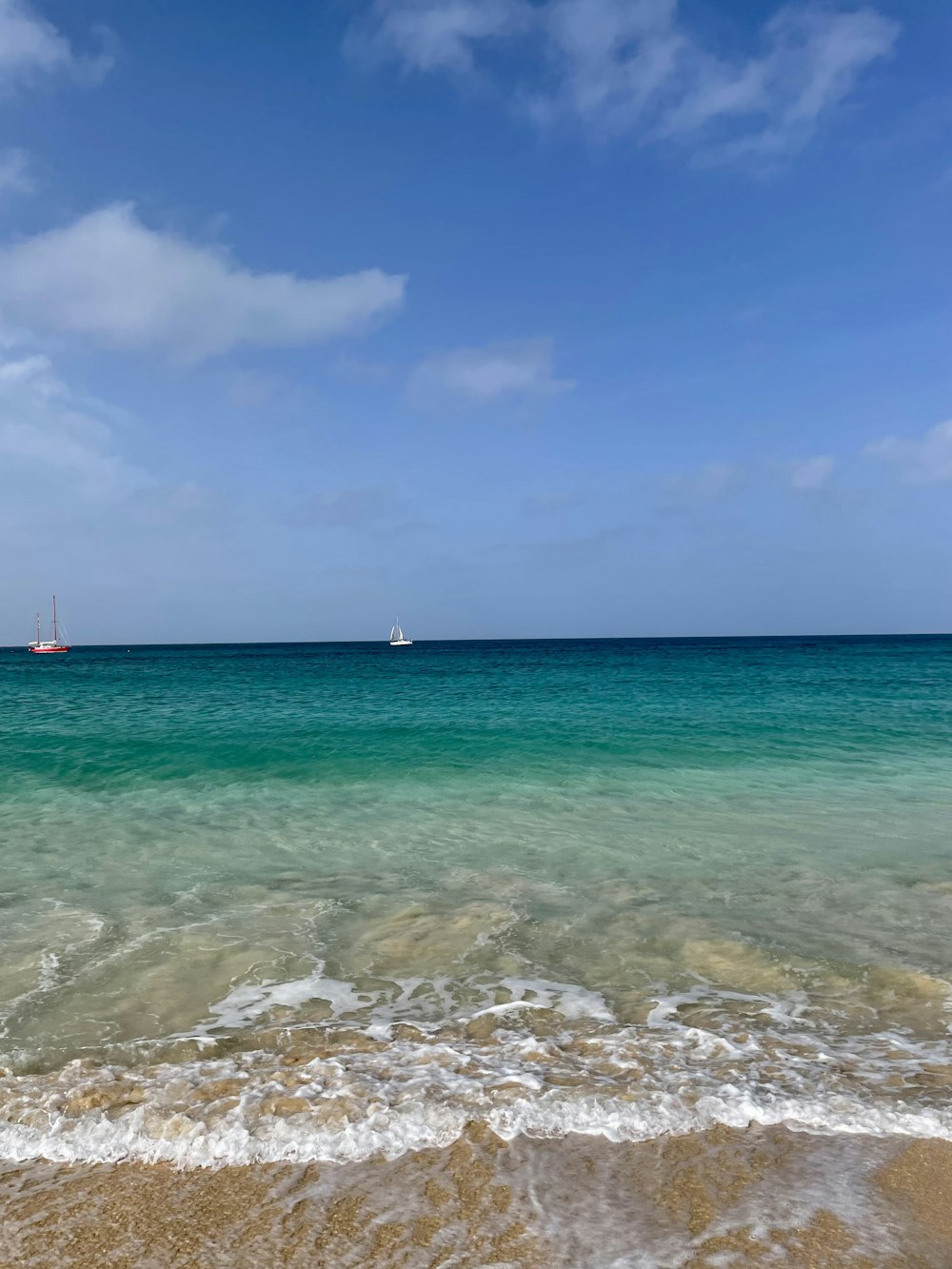 a beach with boats in the water