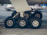 Technician inspecting aircraft landing gear with visible Aero-ID tags attached