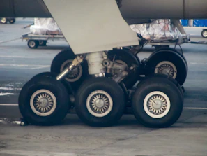 Technician performing detailed checks on airplane landing gear.