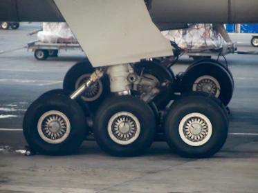Technician performing detailed checks on airplane landing gear.