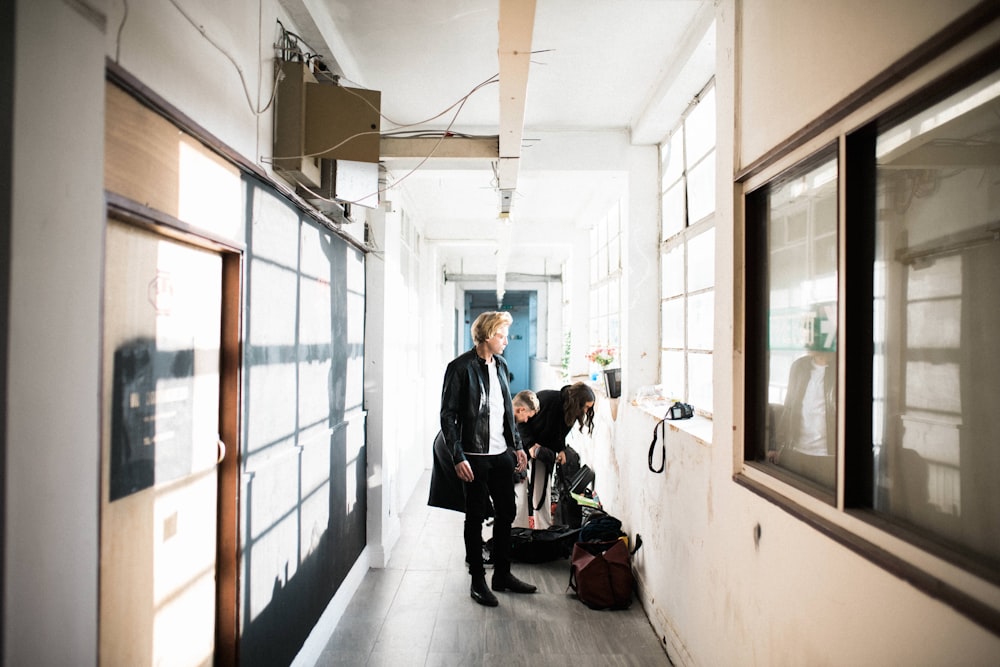 a woman and a man walking down a hallway