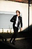 Dynamic shot of a model wearing layered streetwear pieces with deep green accents, captured mid-motion with subtle parallax effect.