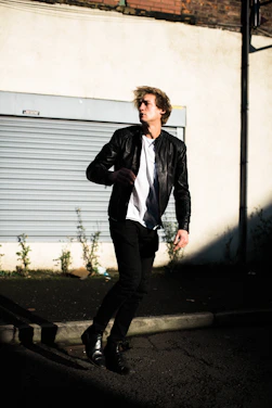 A sleek city street scene with a model wearing a Lumina Apparel jacket, capturing movement and style.