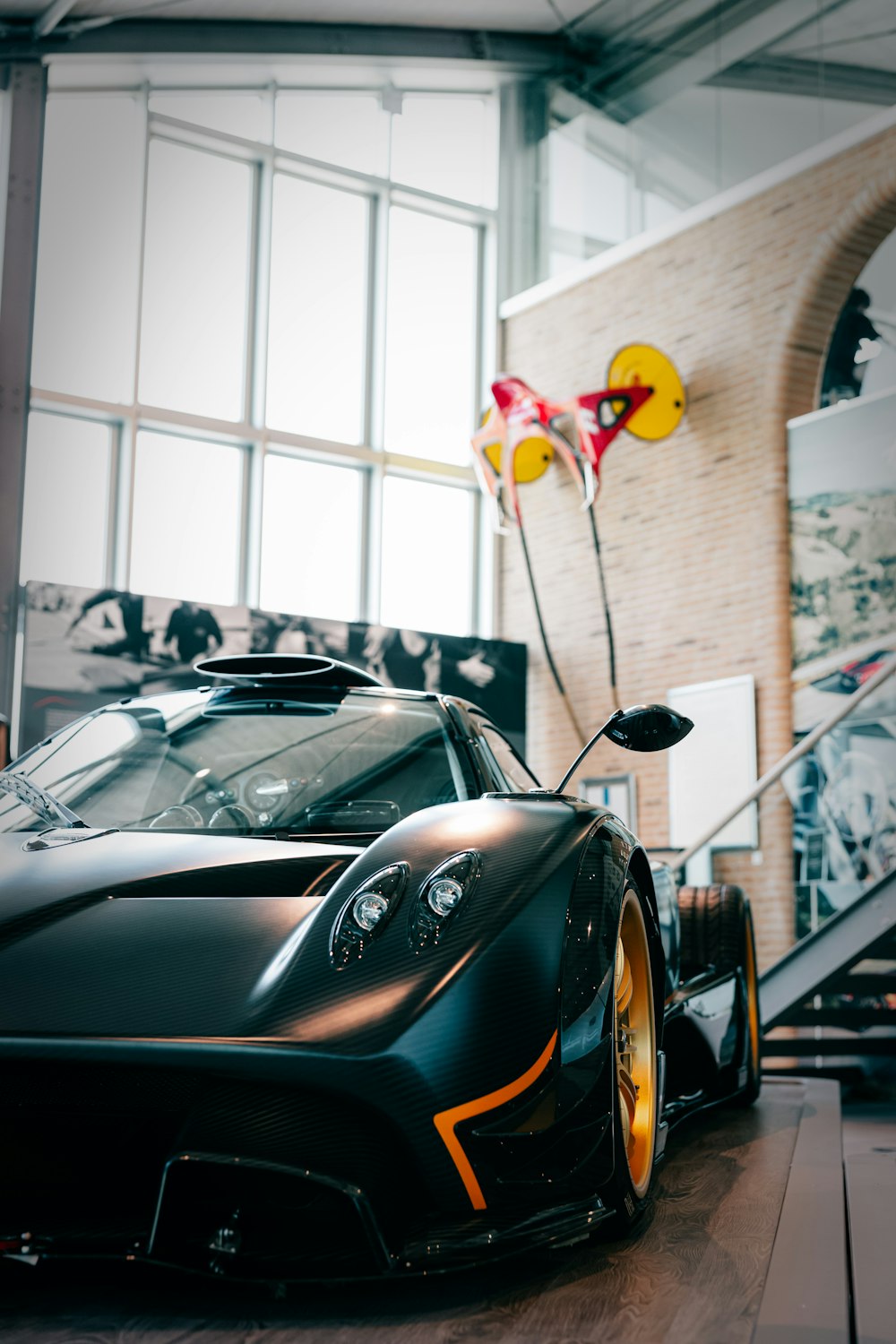 Un auto deportivo negro con un globo unido al techo