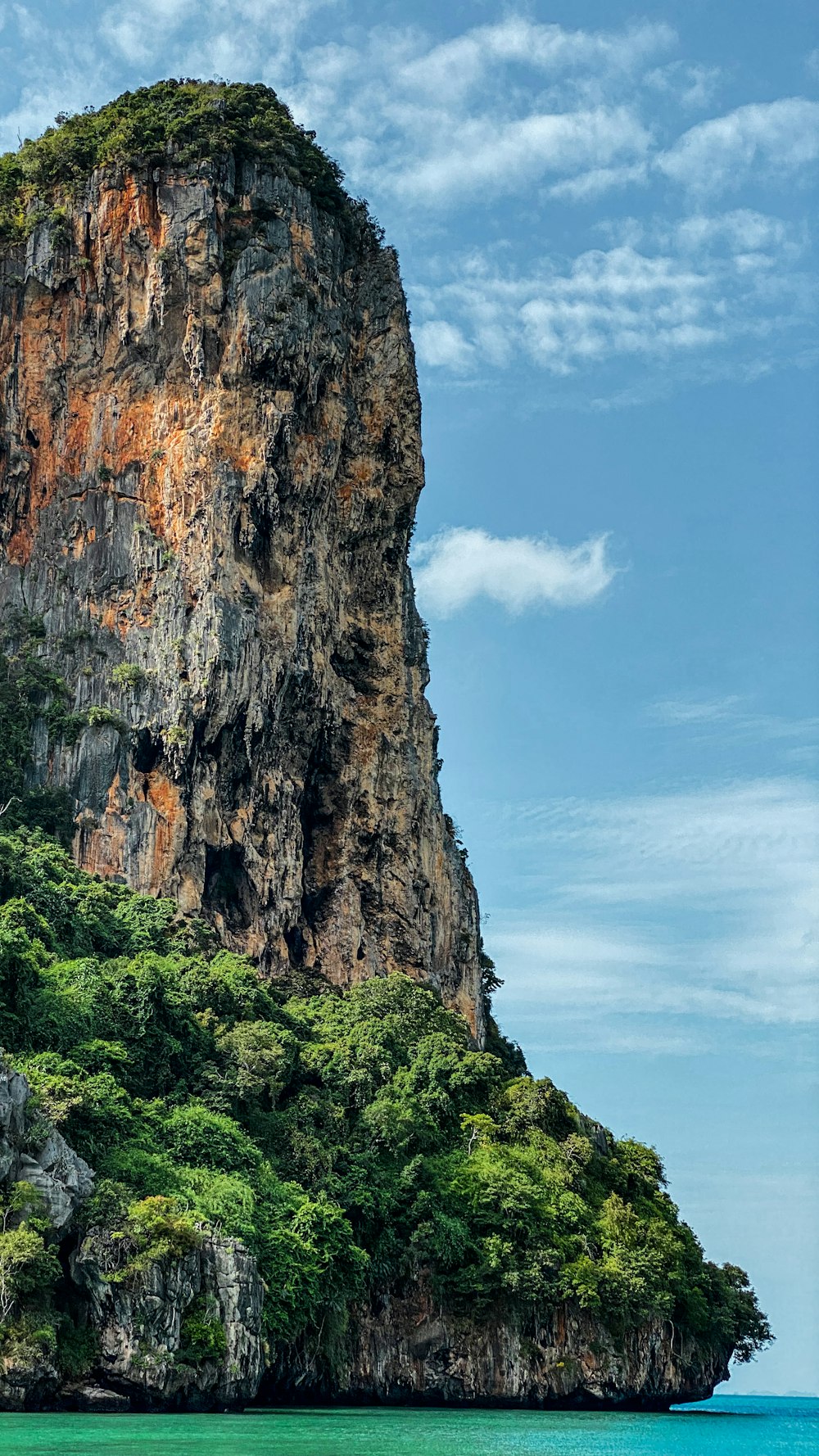 une falaise avec des arbres et un plan d’eau en contrebas