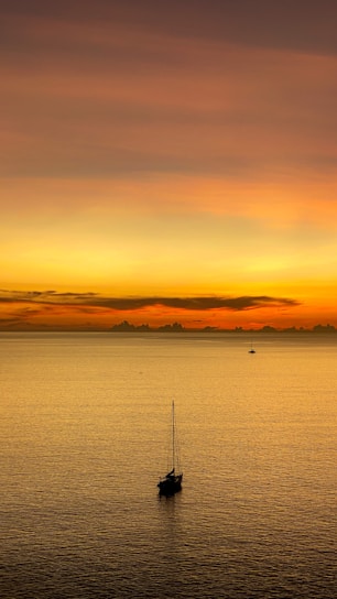 A serene sunset over a calm ocean with a luxury yacht sailing gently, reflecting warm orange hues.