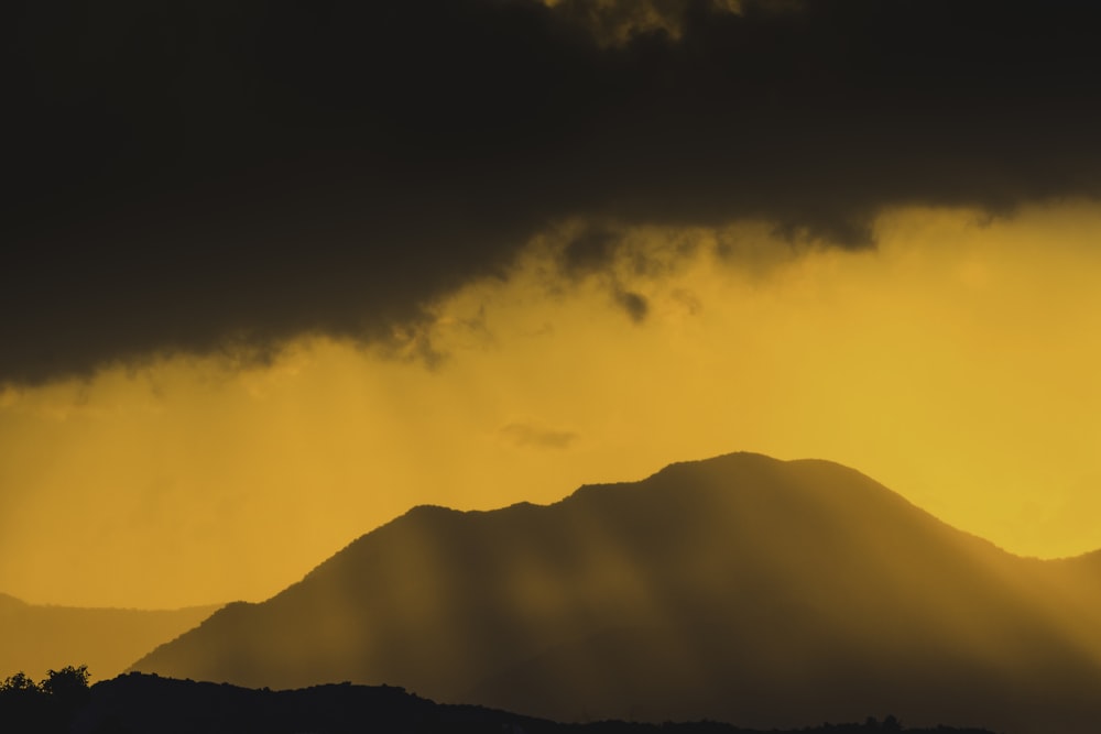 a mountain with a cloudy sky