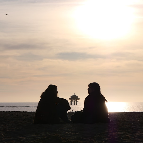 a group of people sitting on a beach