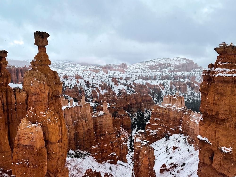 a rocky canyon with snow with Bryce Canyon National Park in the background