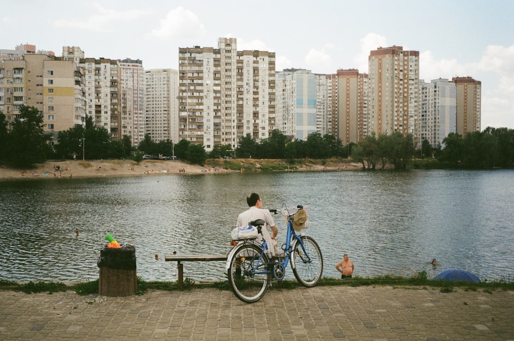 a person riding a bicycle on a bench by a lake