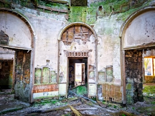 Interior of an abandoned castle with broken windows and faded murals