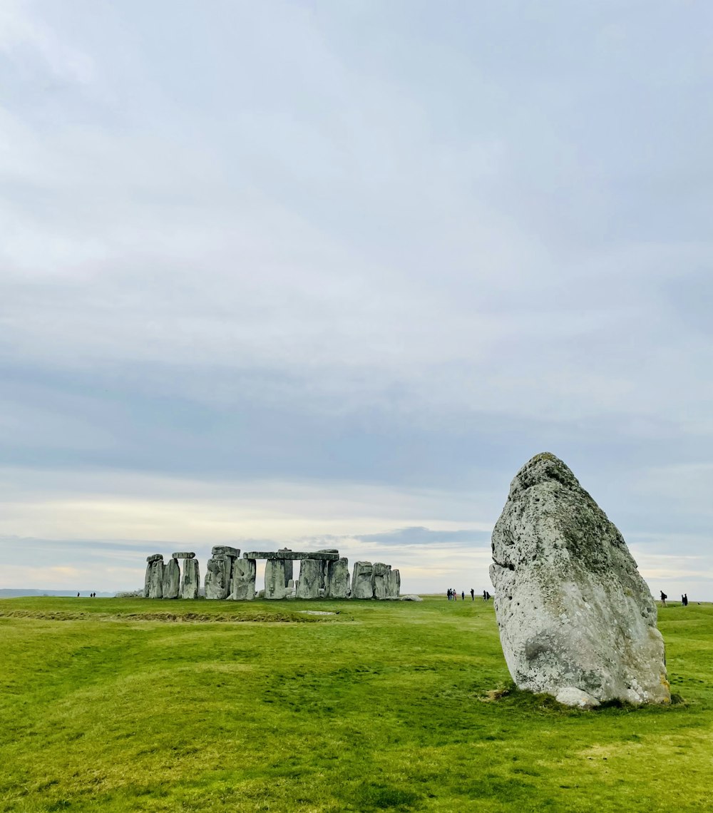 a stone structure in a grassy field