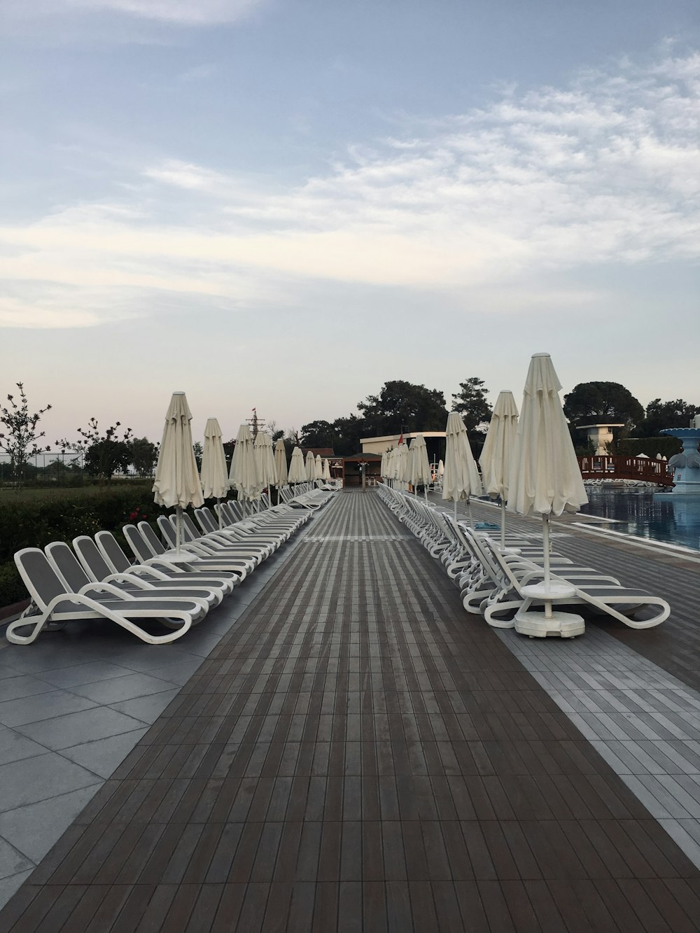 a row of white benches on a boardwalk
