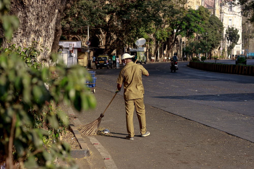 Un hombre con una escoba en una calle