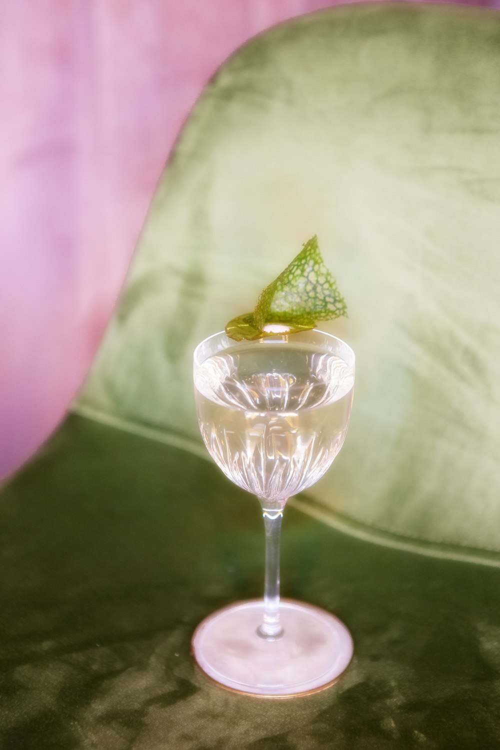 a glass with a green leaf on top of it