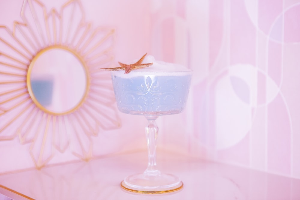 a glass of blue liquid with a gold star on top