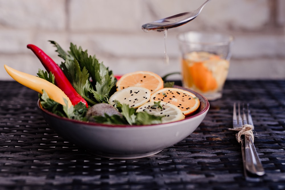 a bowl of food with a glass of juice and a glass of juice