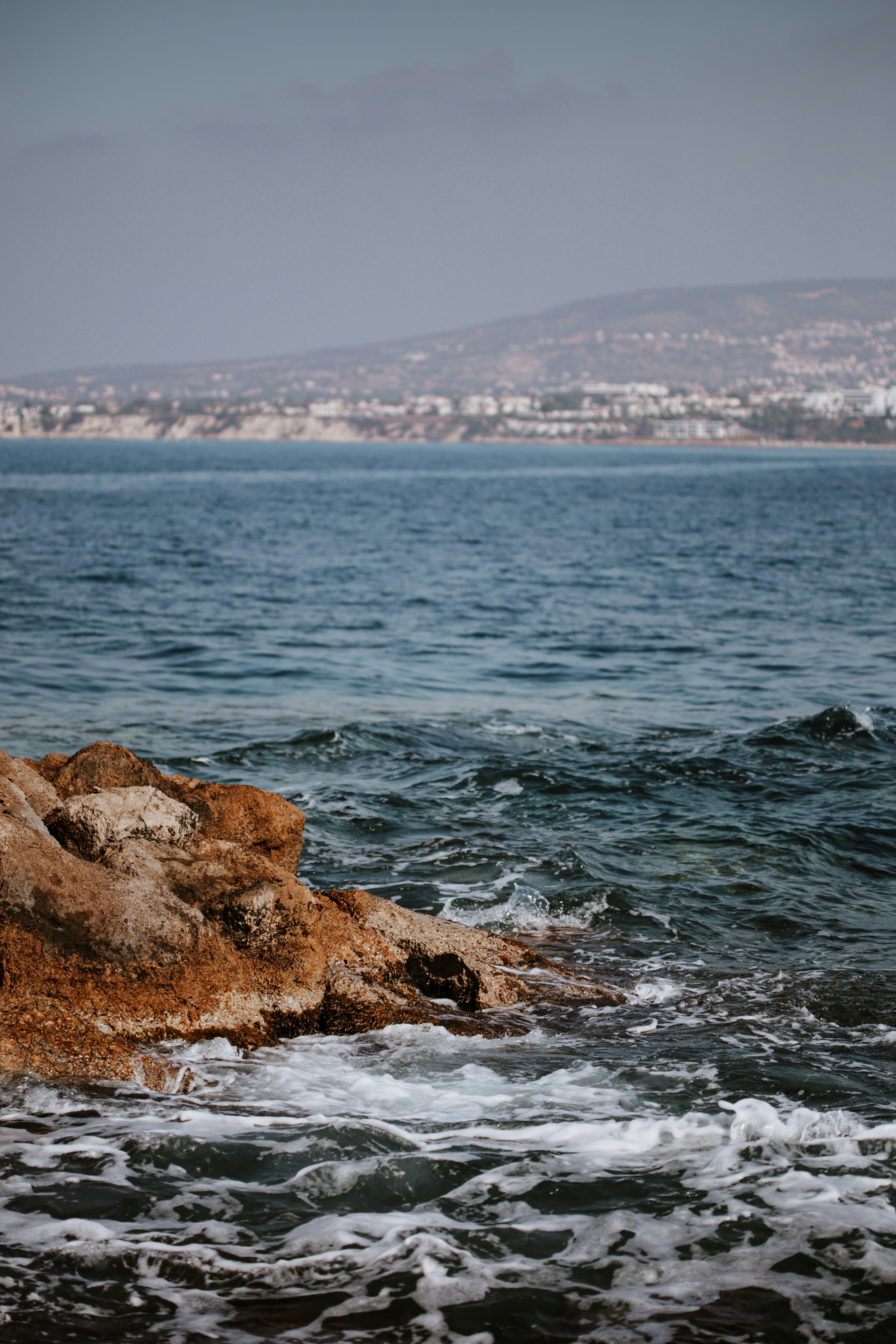 Une plage rocheuse avec une ville en arrière-plan