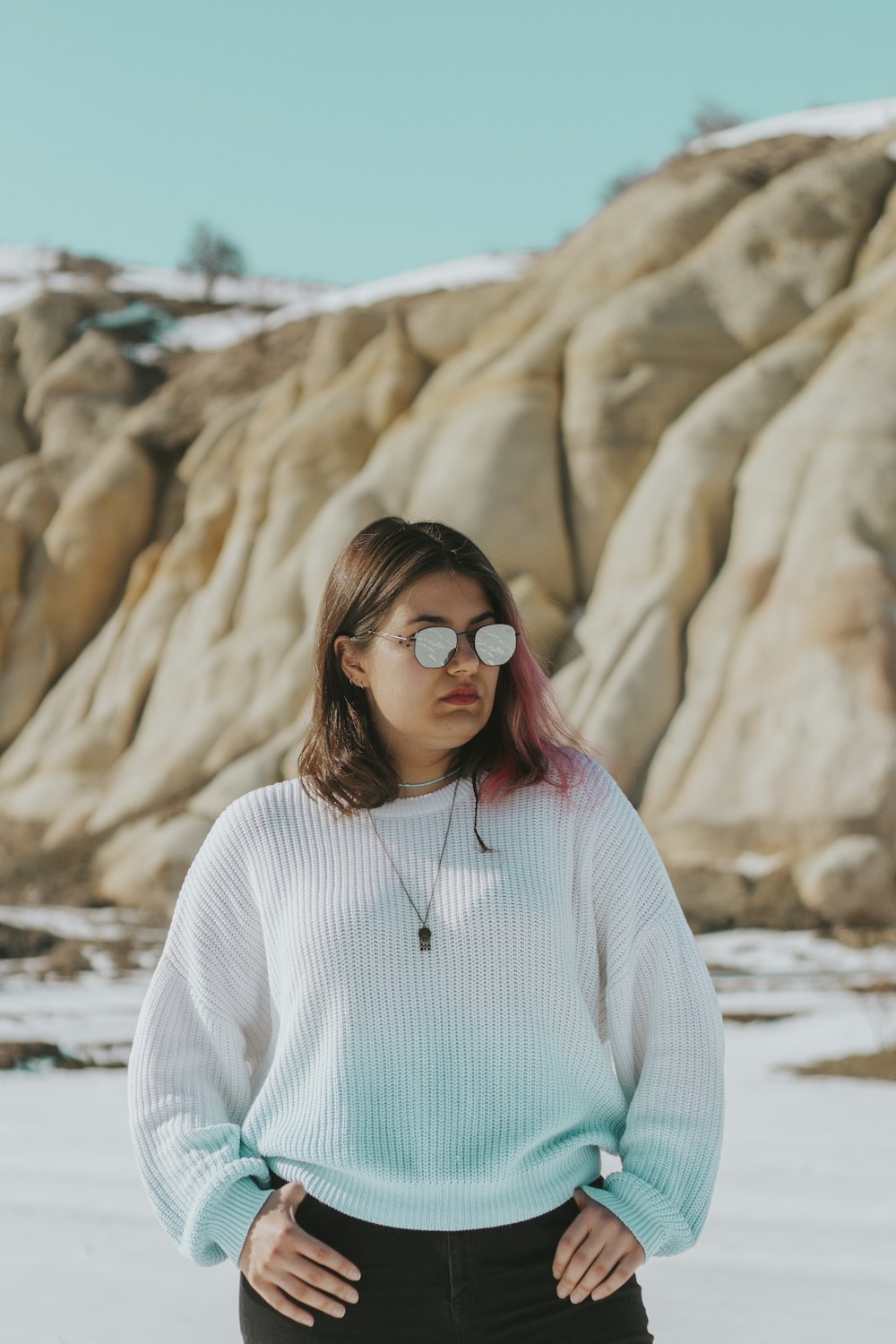 a woman standing in front of a rock formation