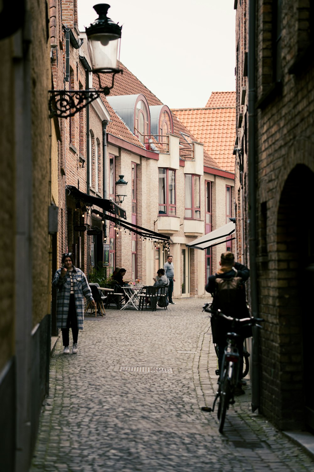 a person riding a bicycle down a cobblestone street