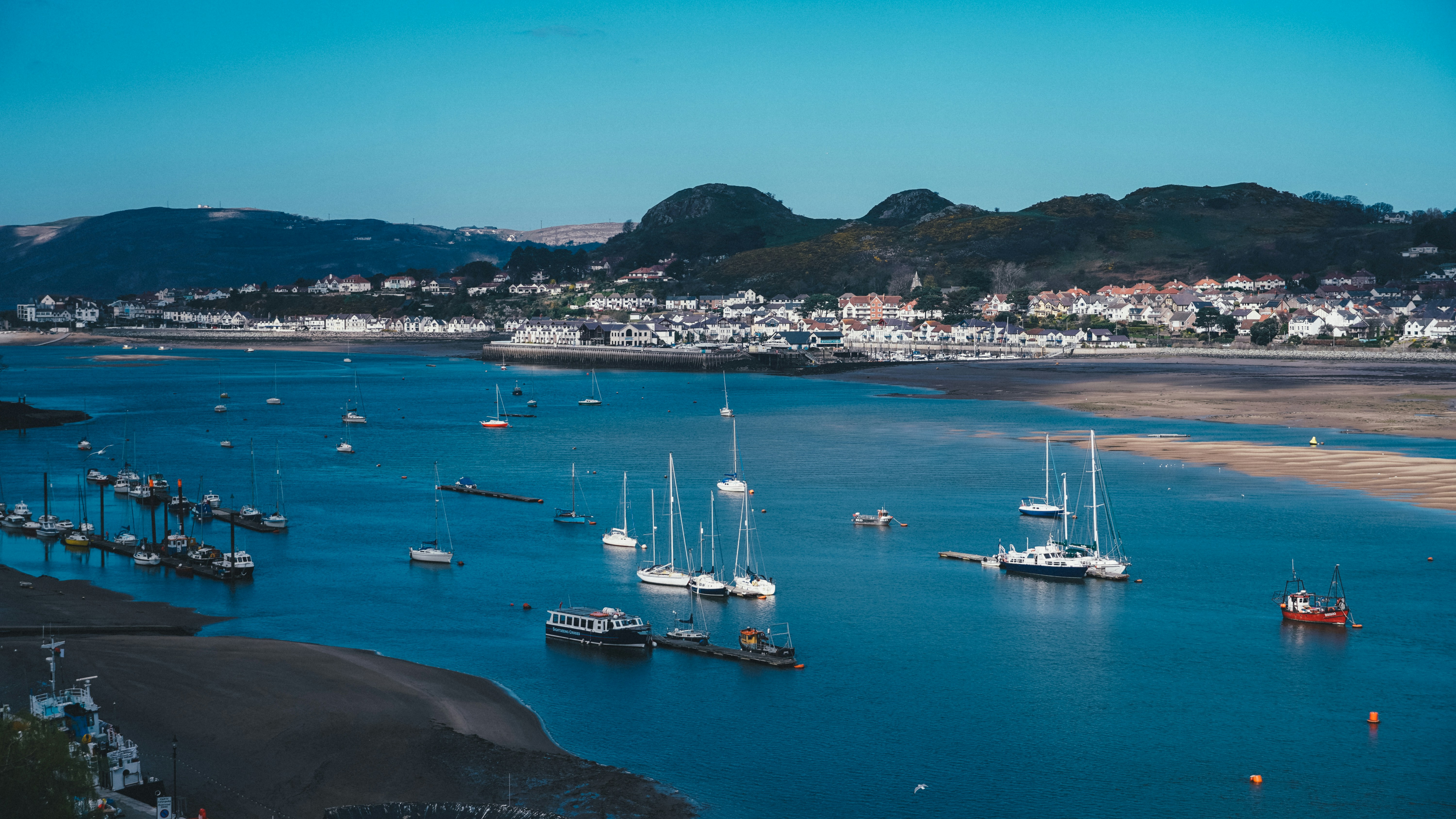 a body of water with boats in it and a city in the background