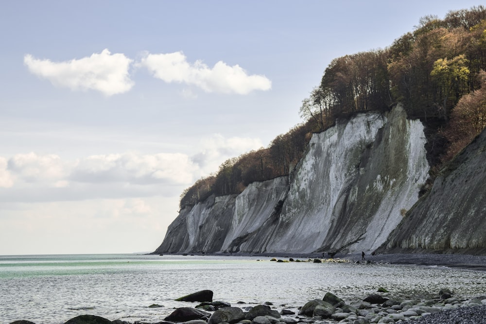 a rocky cliff next to a body of water