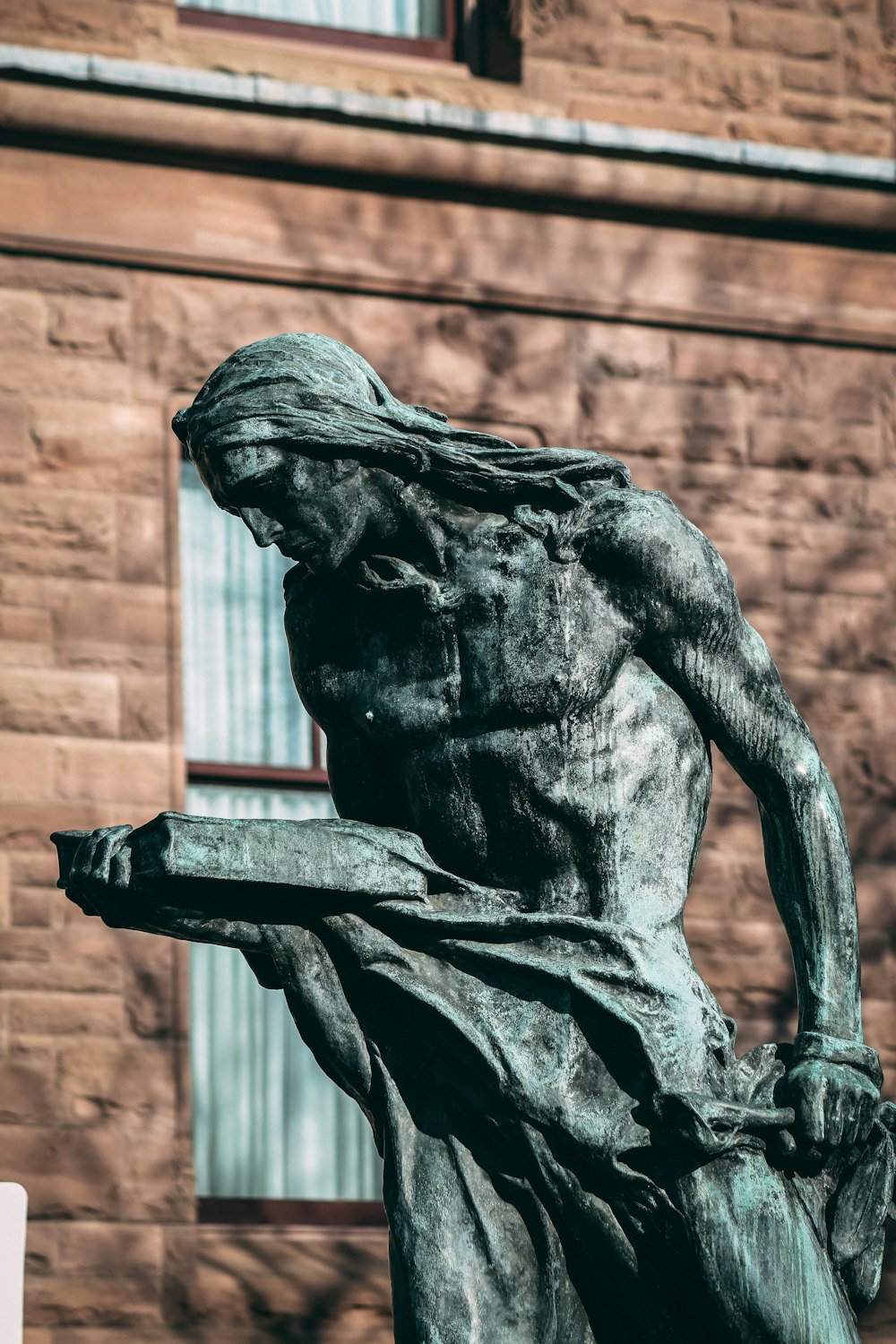 a statue of a person holding a book