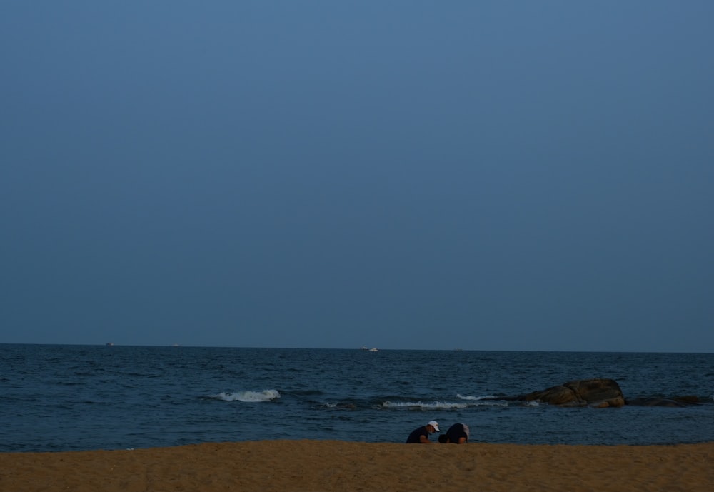 a couple people sitting on a beach