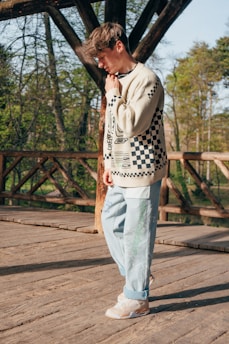 a man standing on a wooden bridge