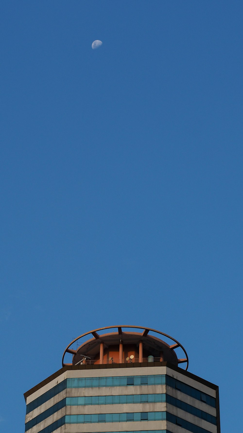 a building with a round tower and a moon in the sky