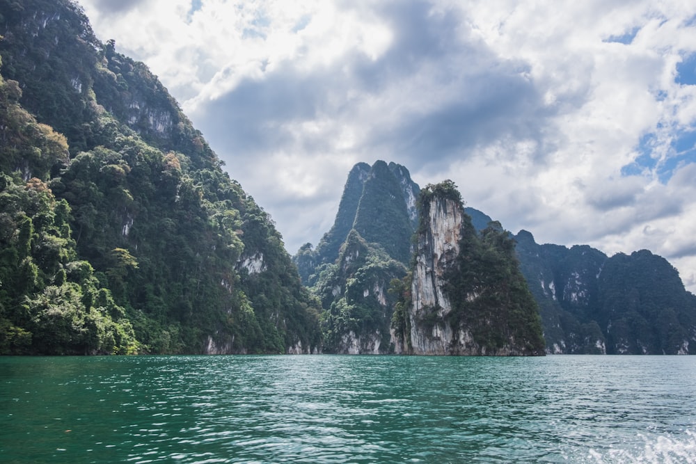 a body of water with trees and mountains in the background