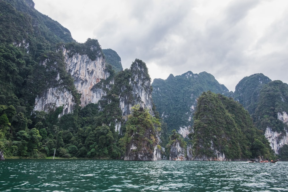 a body of water with trees and mountains in the background