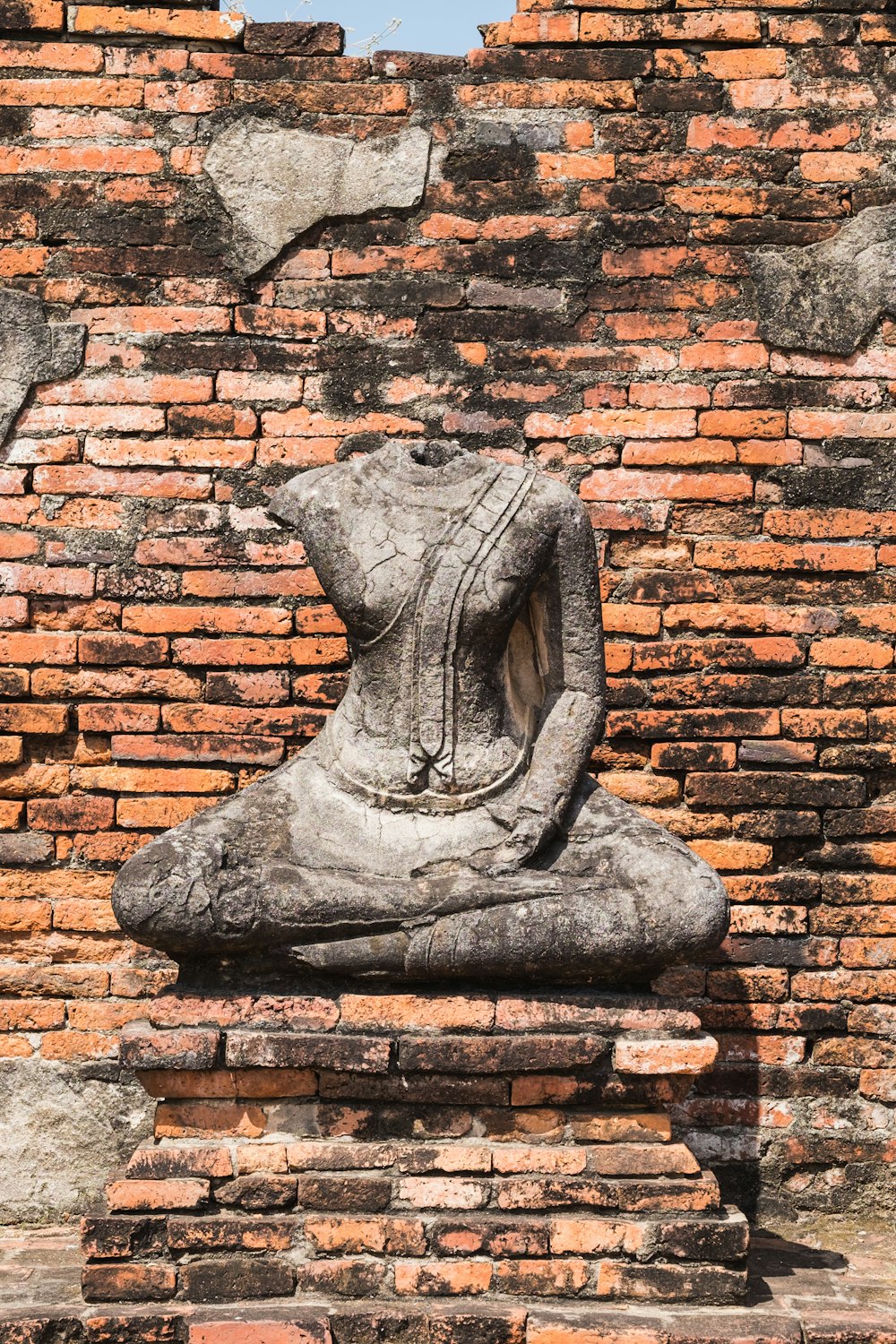 a stone statue on a brick wall