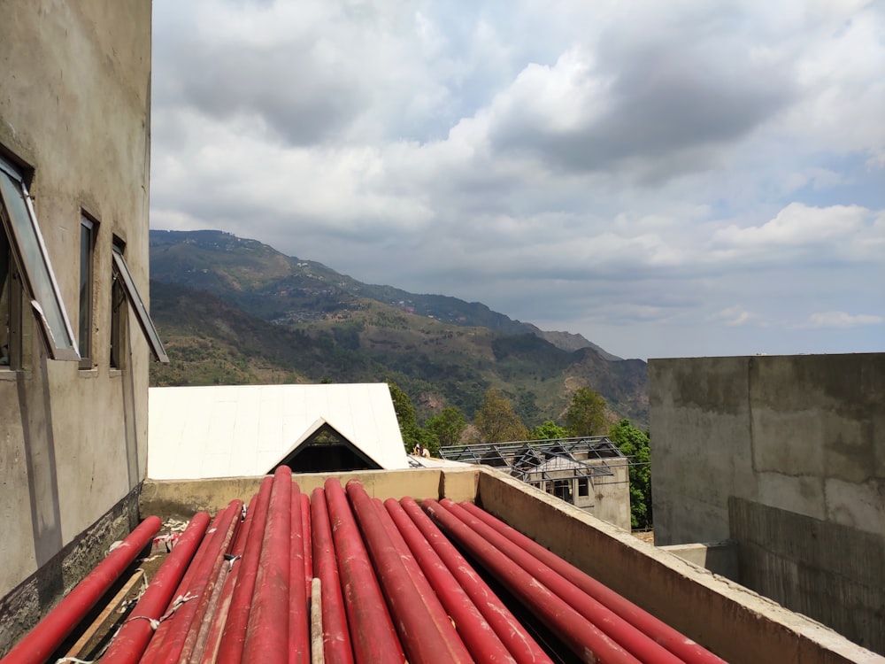 a roof with a red tarp and a building with mountains in the background