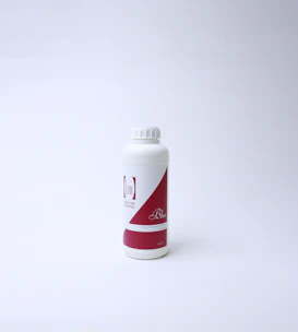 A sleek, modern supplement bottle with a green and white label on a clean white background.