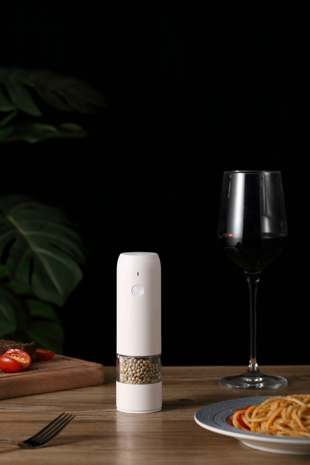 a glass of wine next to a white rectangular object on a wooden surface