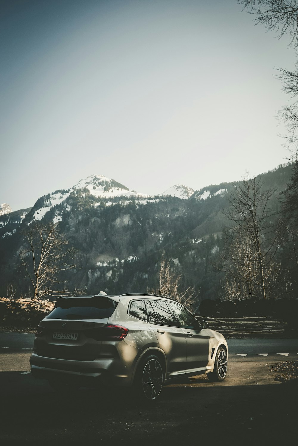 a black sports car parked in front of a snowy mountain