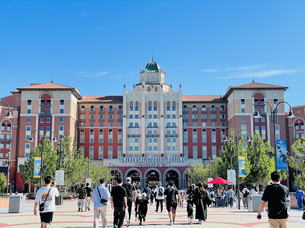 a group of people walking in front of a large building