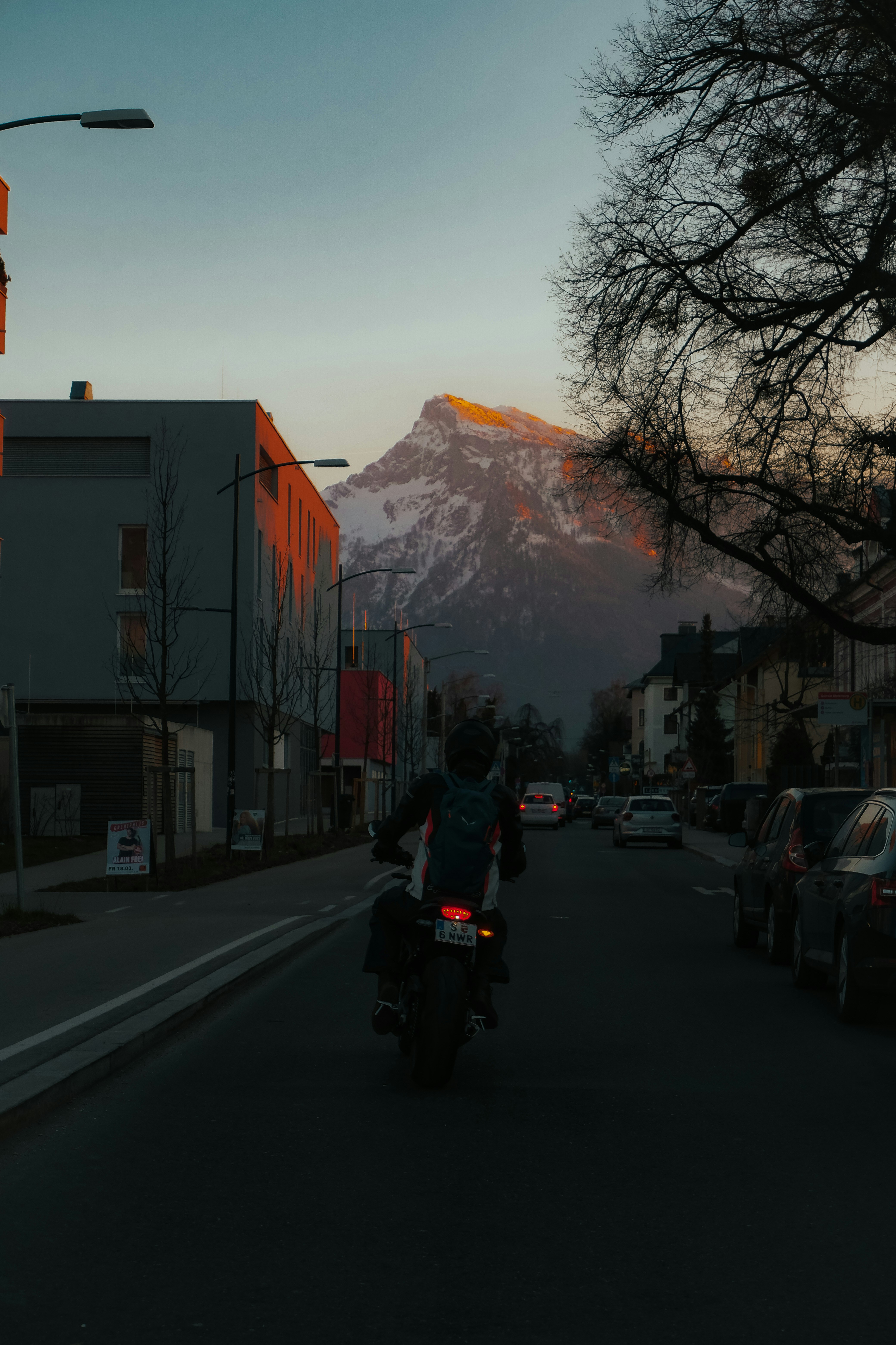a person riding a motorcycle on a street with a mountain in the background