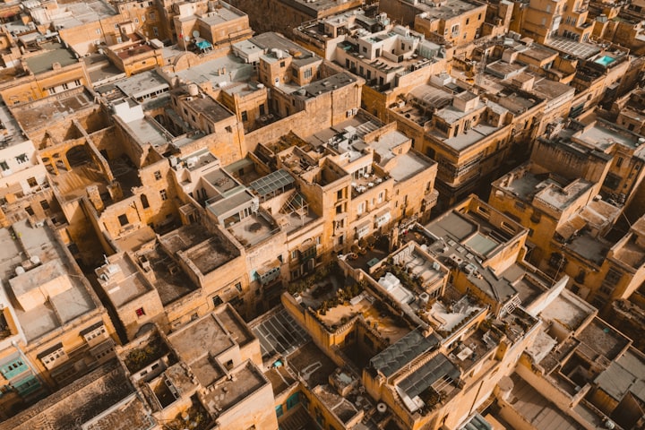 Rooftops of Valletta, brown buidings, Photo by Jaanus Jagomägi / Unsplash