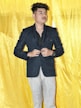a person standing in front of a yellow curtain