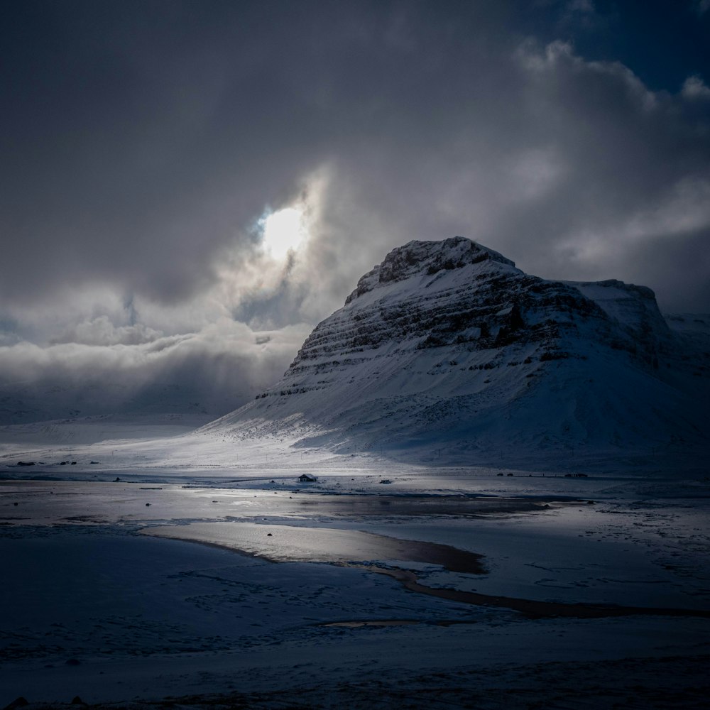 a snowy mountain with a cloudy sky