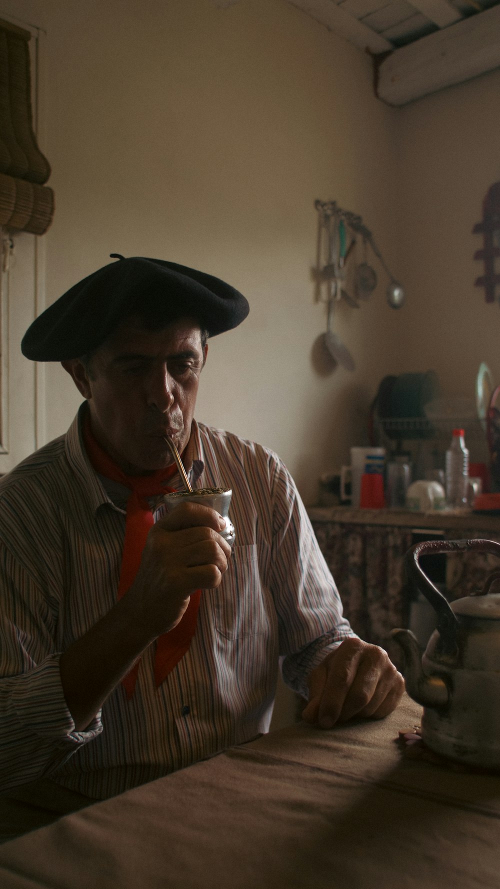 um homem em um chapéu segurando um copo de vinho