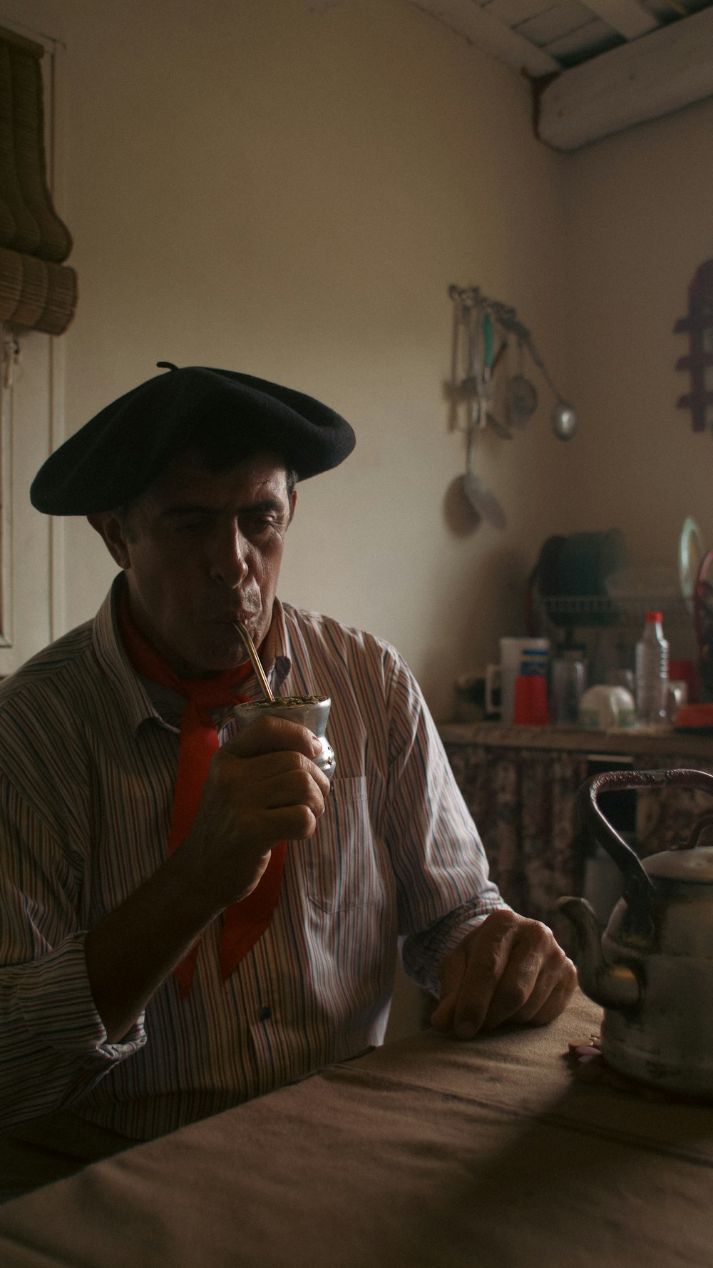 a man in a hat holding a glass of wine