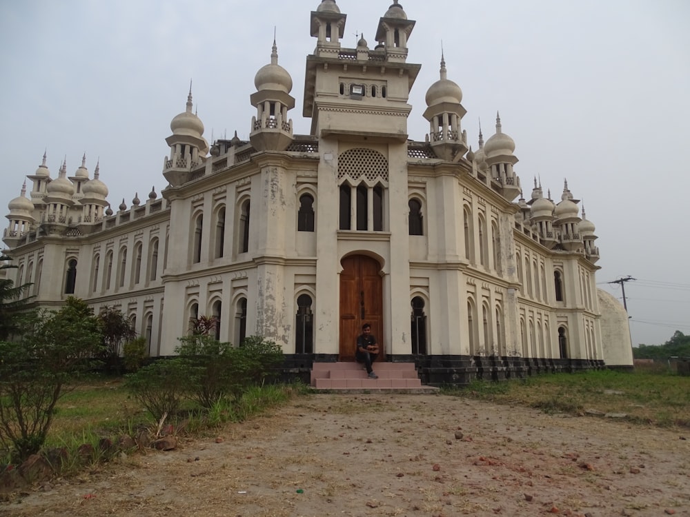 a large white building with a person standing in front of it