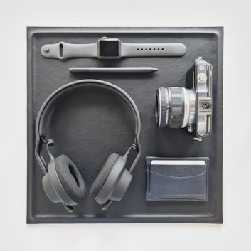 A flat lay of recovery tools including a foam roller, sleep tracker, and a smartphone displaying an app.