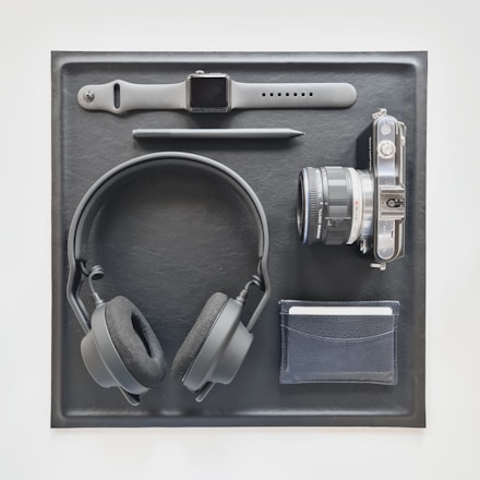 A stylish flat lay featuring fitness gear, luxury watches, and elegant kitchen tools arranged on a wooden table.