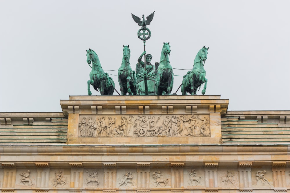 a statue of a group of people with Brandenburg Gate in the background