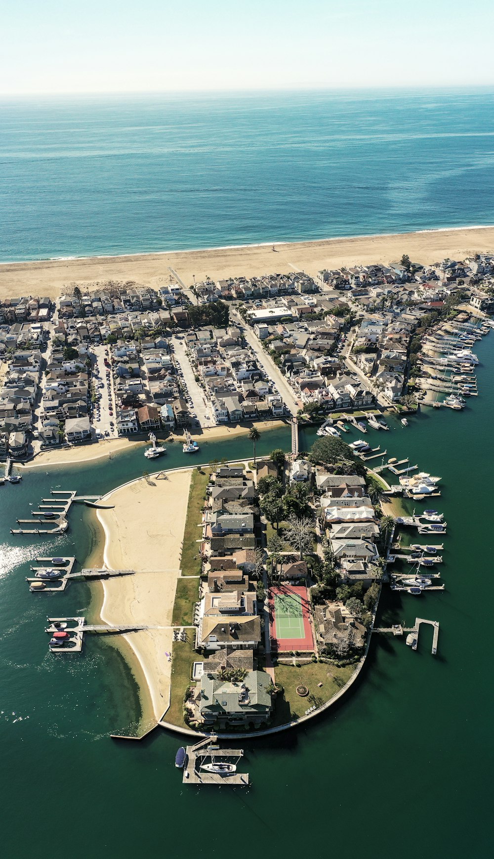 a body of water with boats and a beach with buildings along it